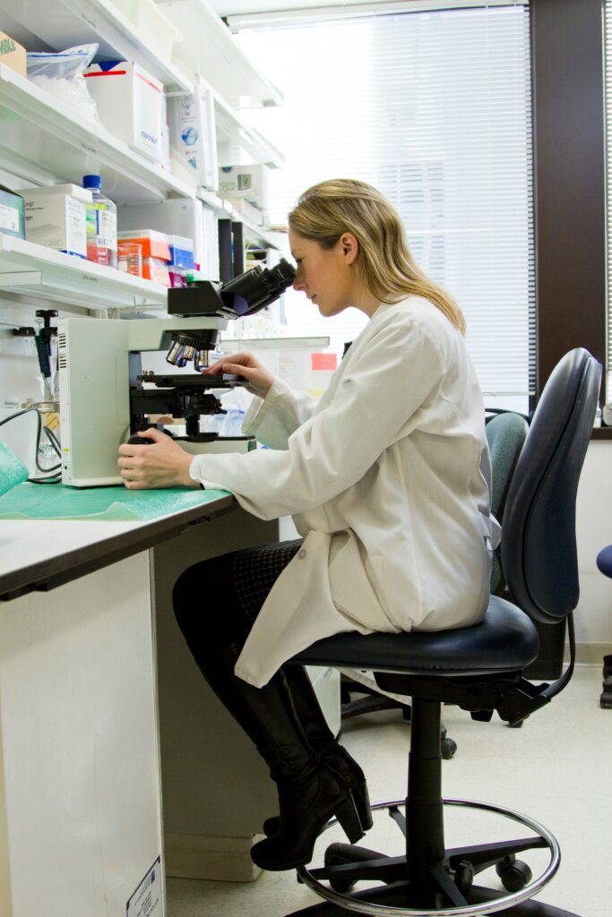 Scientist using a microscope in a laboratory, representing functional nutrition testing